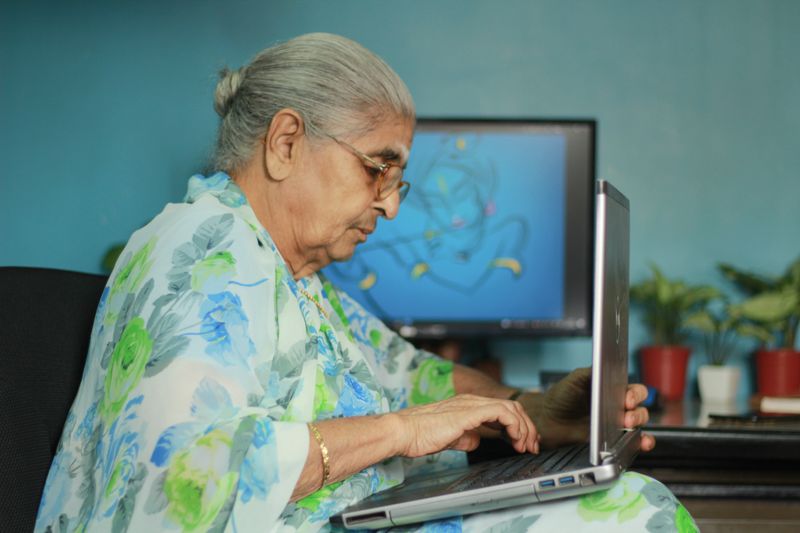 An older woman using a laptop at home