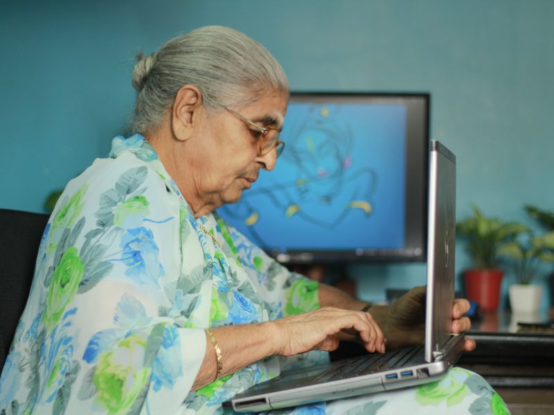 An older woman using a laptop at home
